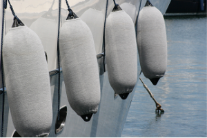 Boat fenders with fender covers on side of a boat