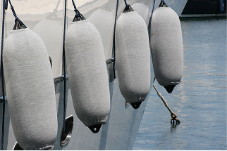 Boat fenders with fender covers on side of a boat